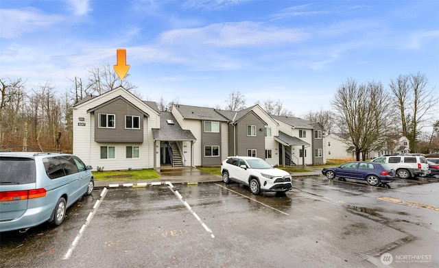 uncovered parking lot featuring a residential view and stairs