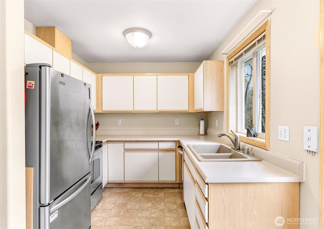 kitchen with stainless steel appliances, stone finish floor, light countertops, and a sink