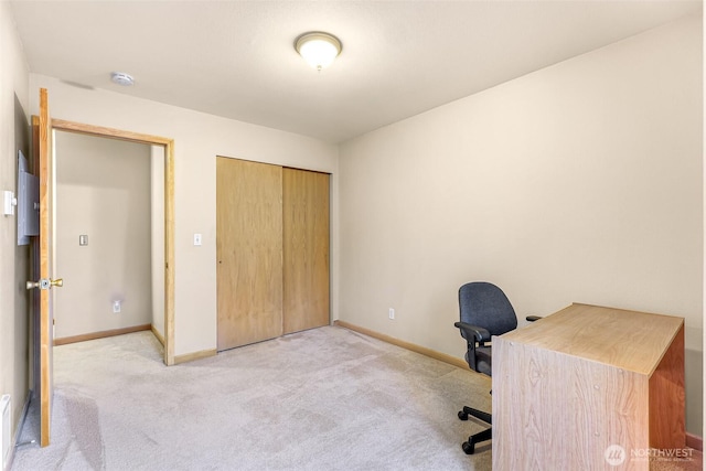 office space featuring light carpet and baseboards