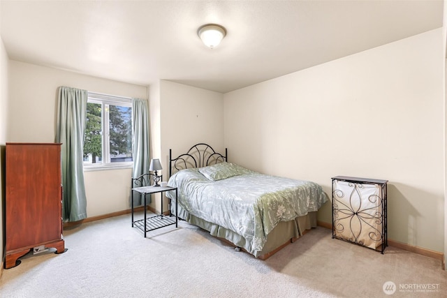 bedroom with light carpet and baseboards