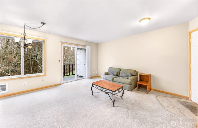 living room featuring light colored carpet, baseboards, and an inviting chandelier