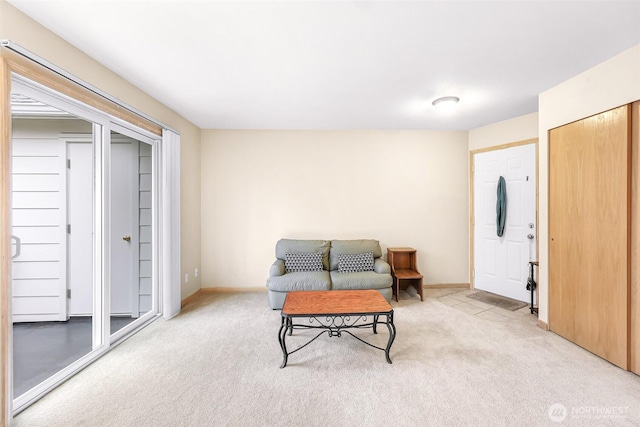 sitting room featuring light colored carpet and baseboards