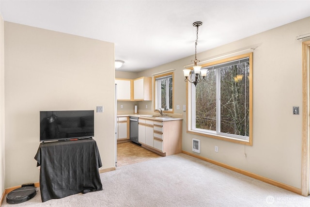 kitchen featuring light colored carpet, hanging light fixtures, light countertops, stainless steel dishwasher, and a sink