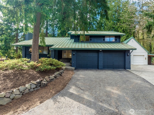 view of front of property with metal roof, brick siding, a standing seam roof, and a chimney