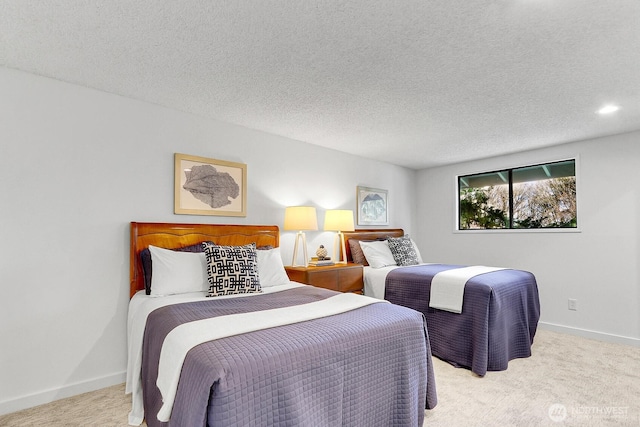 bedroom featuring light carpet, baseboards, and a textured ceiling