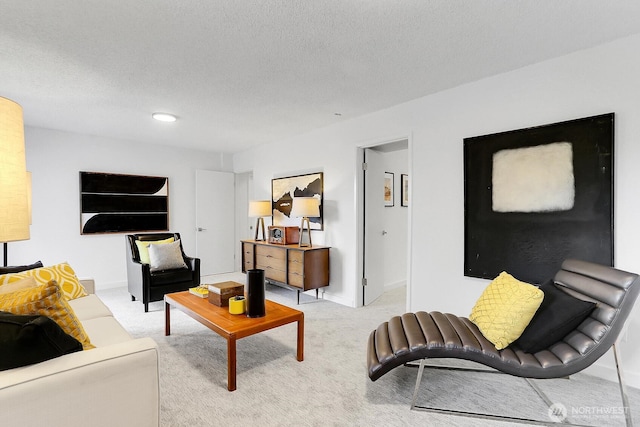 living area featuring light carpet, a textured ceiling, and baseboards