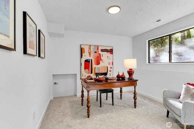 carpeted home office featuring baseboards, visible vents, and a textured ceiling