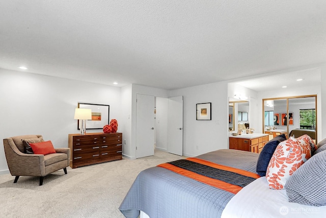 bedroom featuring a textured ceiling, ensuite bathroom, recessed lighting, light colored carpet, and baseboards