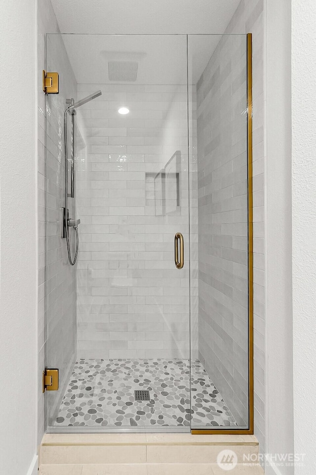 bathroom featuring a shower stall and visible vents