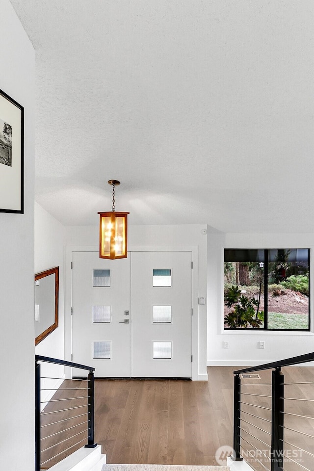 entrance foyer featuring a textured ceiling and wood finished floors