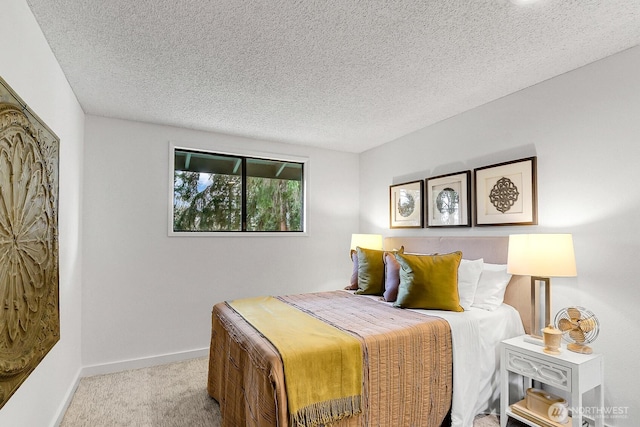 bedroom with carpet, baseboards, and a textured ceiling