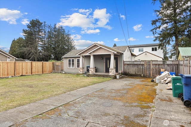 view of front of property featuring covered porch, fence, and a front yard