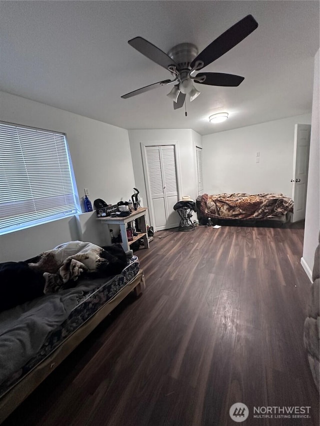 bedroom with dark wood-style floors and a ceiling fan