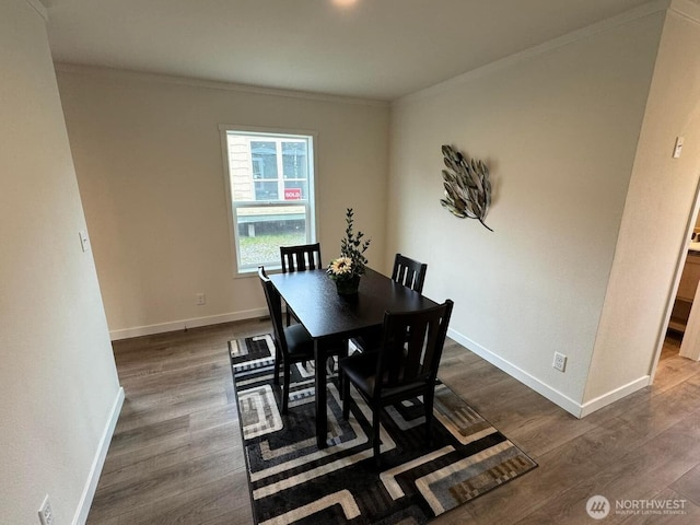 dining area with crown molding, baseboards, and dark wood-type flooring