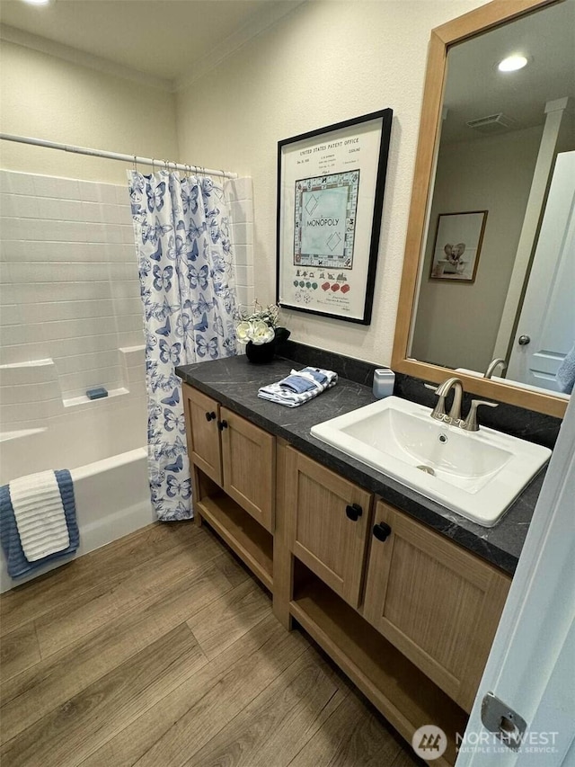 bathroom featuring ornamental molding, shower / tub combo, wood finished floors, and vanity