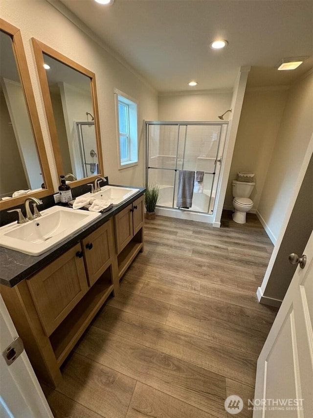 full bath with double vanity, wood finished floors, and a sink