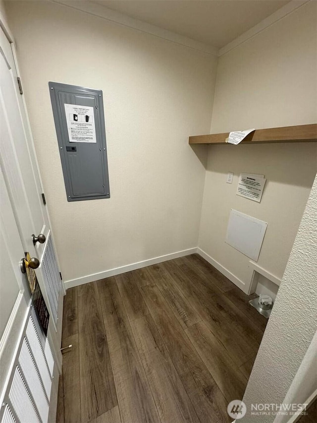 washroom featuring dark wood-style floors, laundry area, electric panel, and crown molding