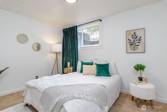 bedroom with light colored carpet and baseboards