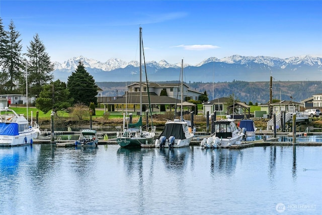 view of water feature with a residential view, a mountain view, and a floating dock