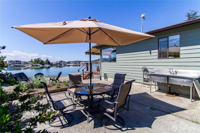 view of patio with outdoor dining space and a water view