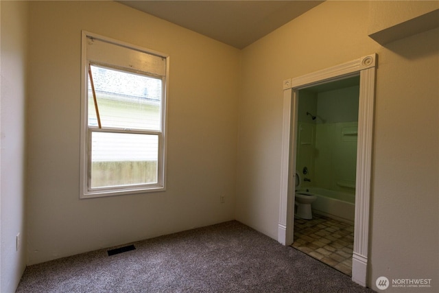 unfurnished bedroom with carpet, visible vents, and ensuite bath