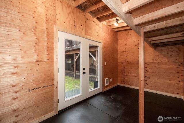 doorway to outside with french doors and wooden walls