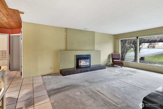 unfurnished living room featuring light colored carpet, a textured ceiling, and light tile patterned floors