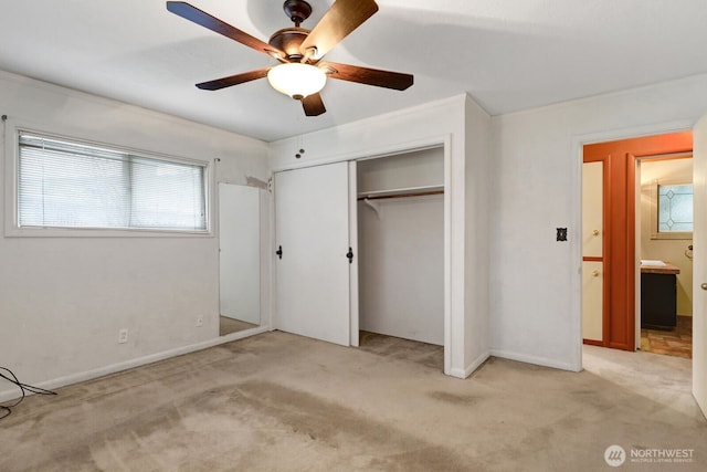 unfurnished bedroom with light carpet, ceiling fan, a closet, and baseboards