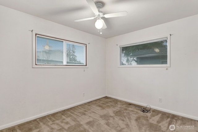 unfurnished room featuring a ceiling fan, light carpet, and baseboards