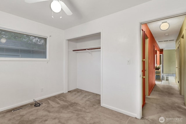 unfurnished bedroom featuring light colored carpet, a closet, visible vents, and baseboards