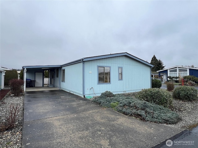 view of side of property with driveway and a carport