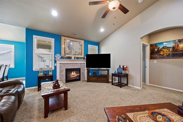 living area with lofted ceiling, carpet, visible vents, and a tile fireplace