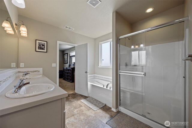 full bathroom featuring a stall shower, visible vents, a sink, and a garden tub