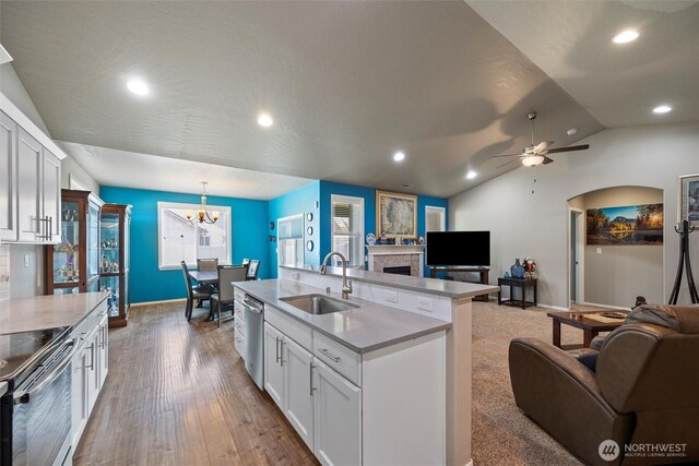 kitchen featuring a sink, open floor plan, hanging light fixtures, appliances with stainless steel finishes, and light countertops