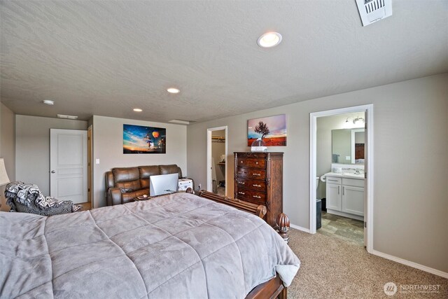 bedroom with visible vents, light colored carpet, a spacious closet, a textured ceiling, and baseboards