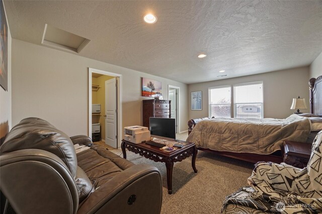 living area featuring attic access, recessed lighting, light carpet, and a textured ceiling