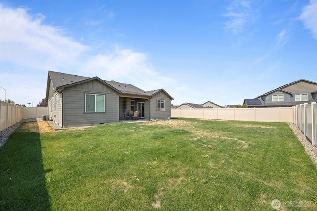 back of property featuring a yard, board and batten siding, a fenced backyard, and central air condition unit