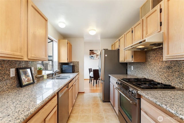 kitchen featuring stainless steel appliances, light brown cabinets, a sink, and under cabinet range hood