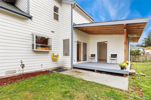 exterior space with a deck, a yard, and fence