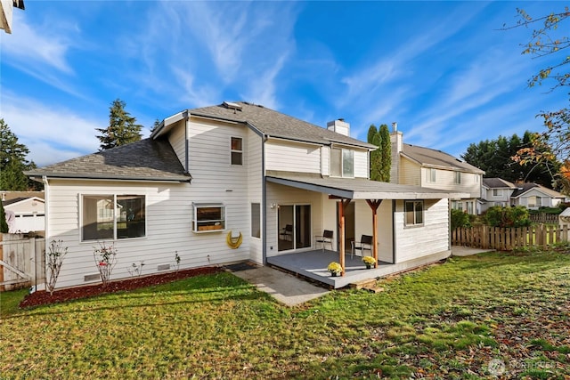 rear view of property with a yard, a patio area, and fence