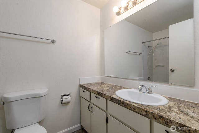 bathroom with toilet, walk in shower, and vanity