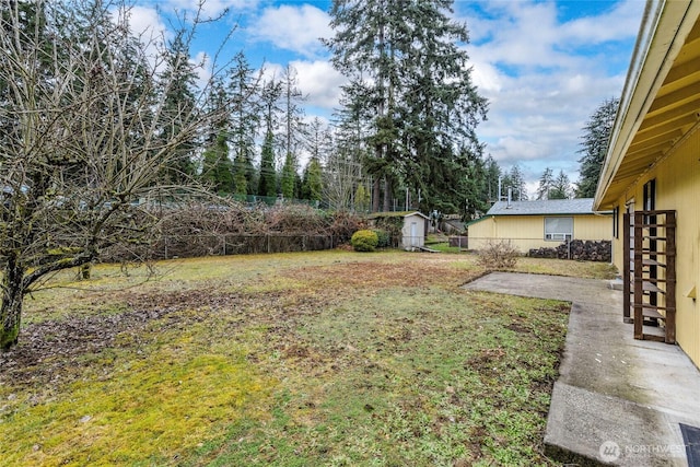 view of yard with an outbuilding, a fenced backyard, a patio, and a shed