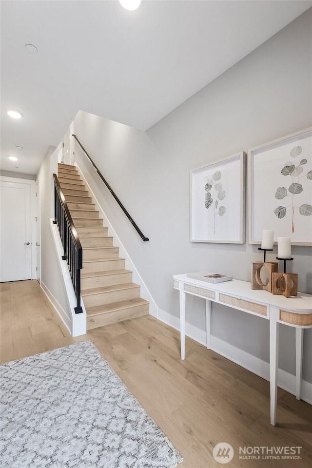 staircase featuring recessed lighting, wood finished floors, and baseboards