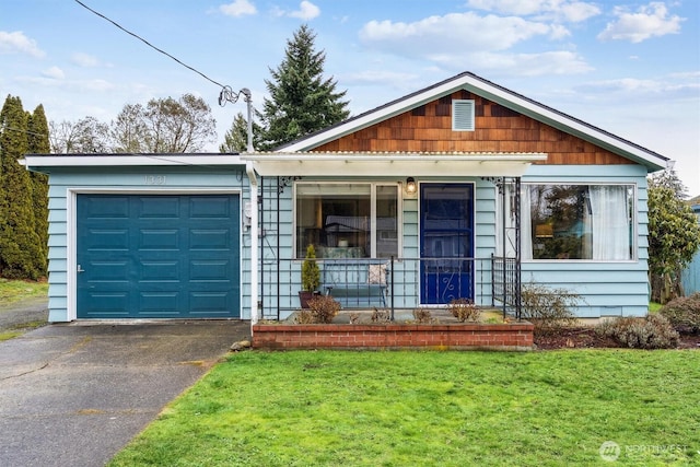 view of front of property with aphalt driveway, a porch, an attached garage, and a front yard