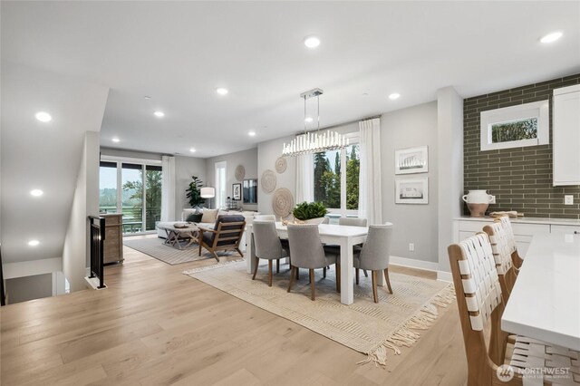 dining space featuring baseboards, light wood finished floors, plenty of natural light, and recessed lighting