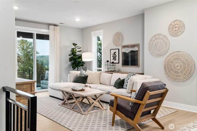 living area featuring light wood finished floors, baseboards, and recessed lighting