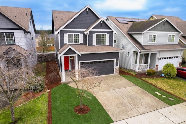 view of front of house featuring a garage, solar panels, a front lawn, and driveway