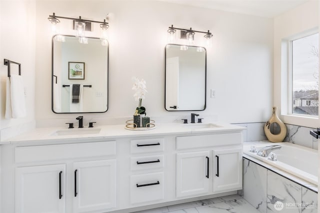 full bathroom with marble finish floor, a sink, a bath, and double vanity