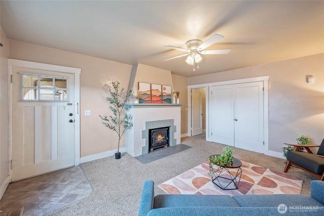 carpeted living room with ceiling fan and baseboards