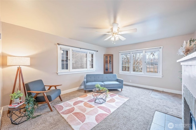 living area featuring carpet, a fireplace with flush hearth, and baseboards